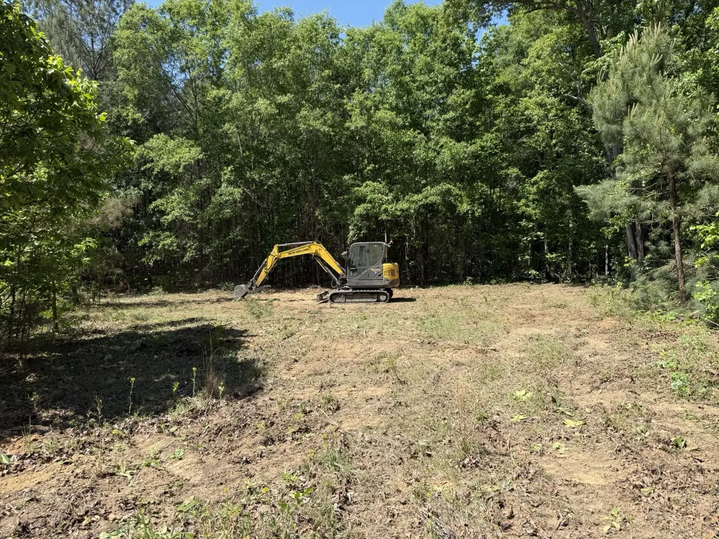 Hunter Houses mini excavator clearing brush on a wooded lot near Florence, SC